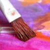 Aritist brush on brightly colored canvas
