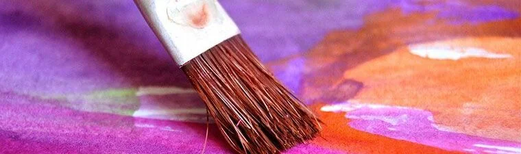 Aritist brush on brightly colored canvas